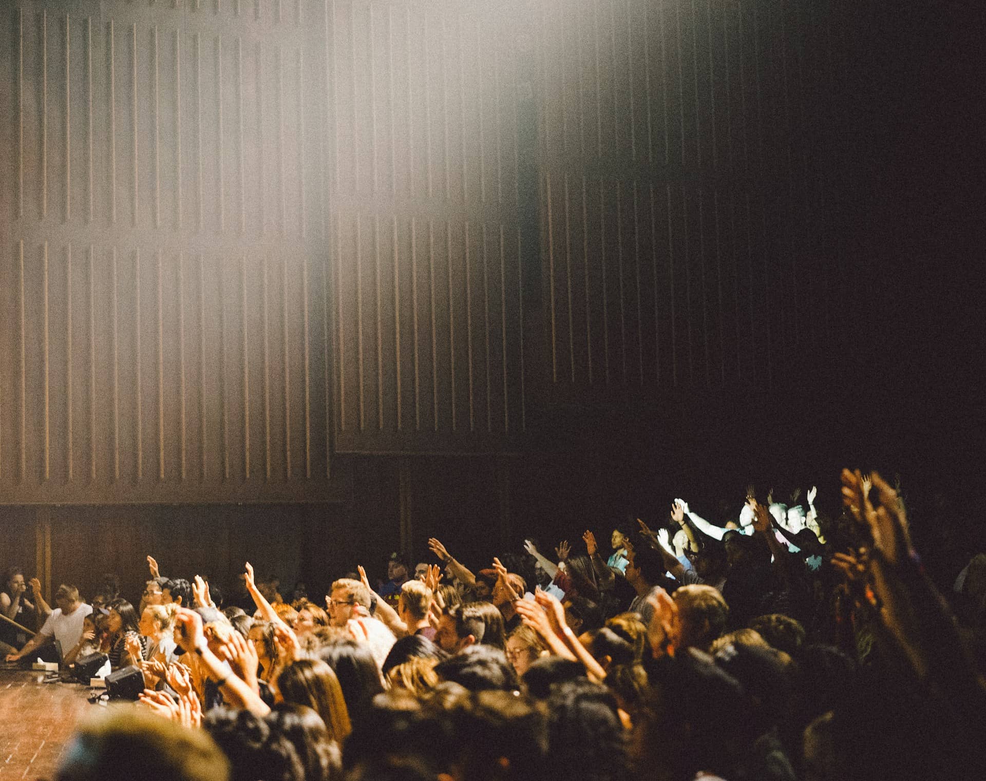 People raising their hands in a lecture or classroom setting